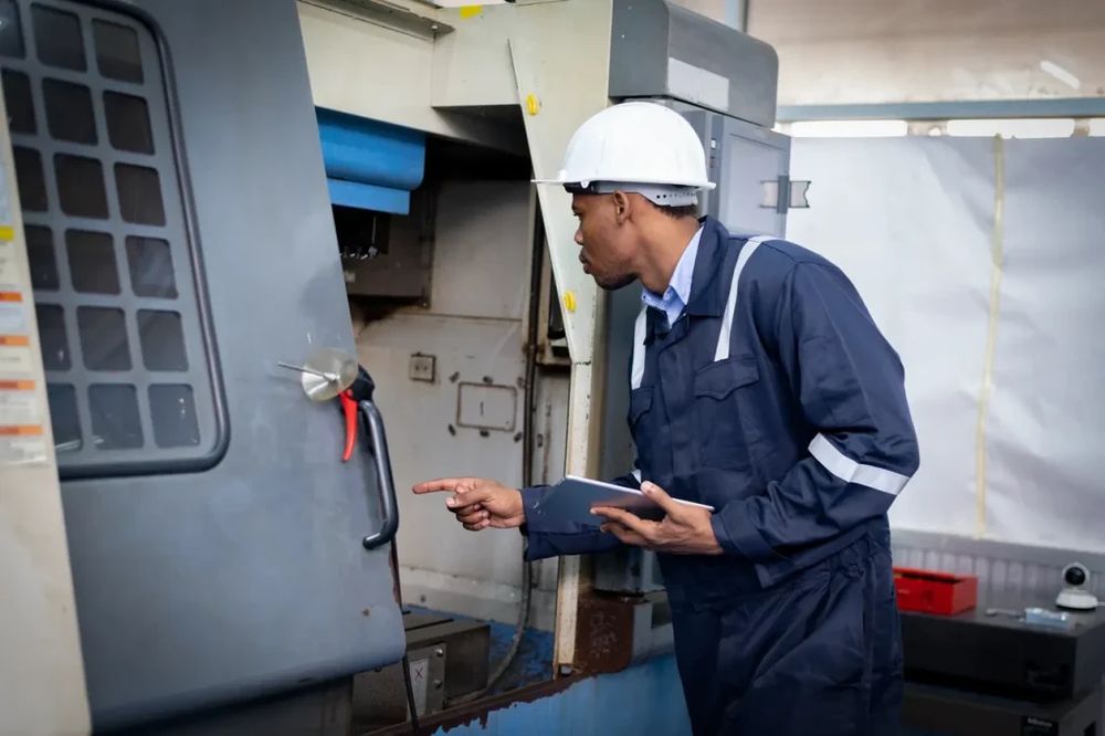 Remotix technician inspecting an industrial machine with a tablet